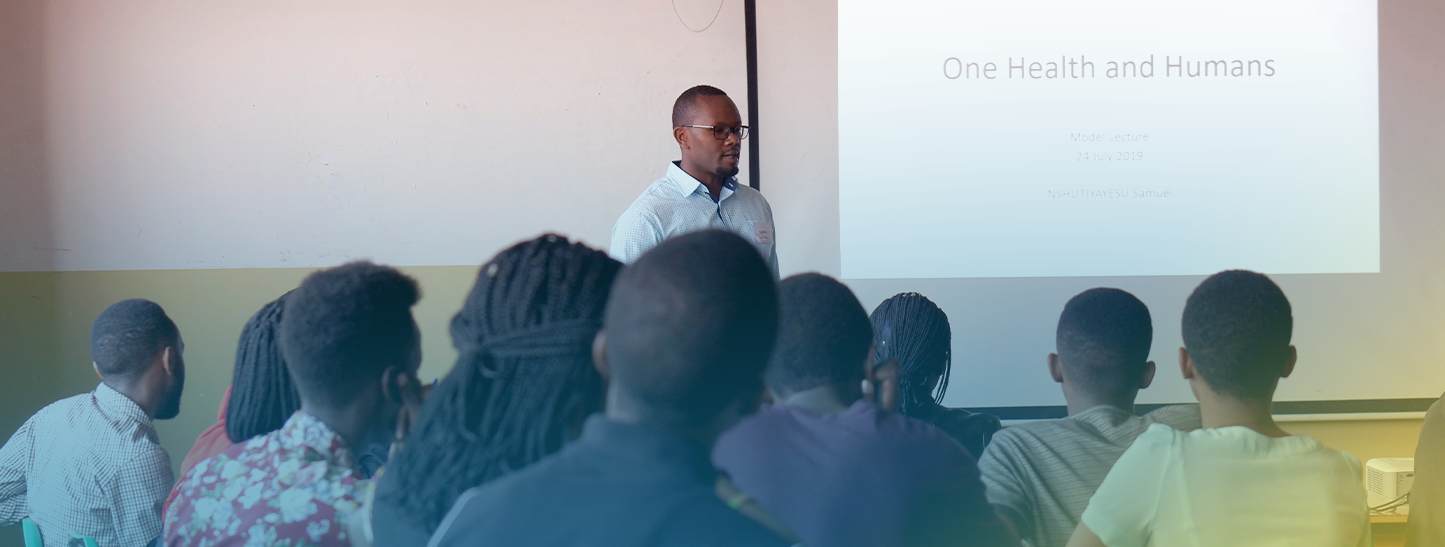 Male Rwandan professor lecturing to a class in front of a presentation screen