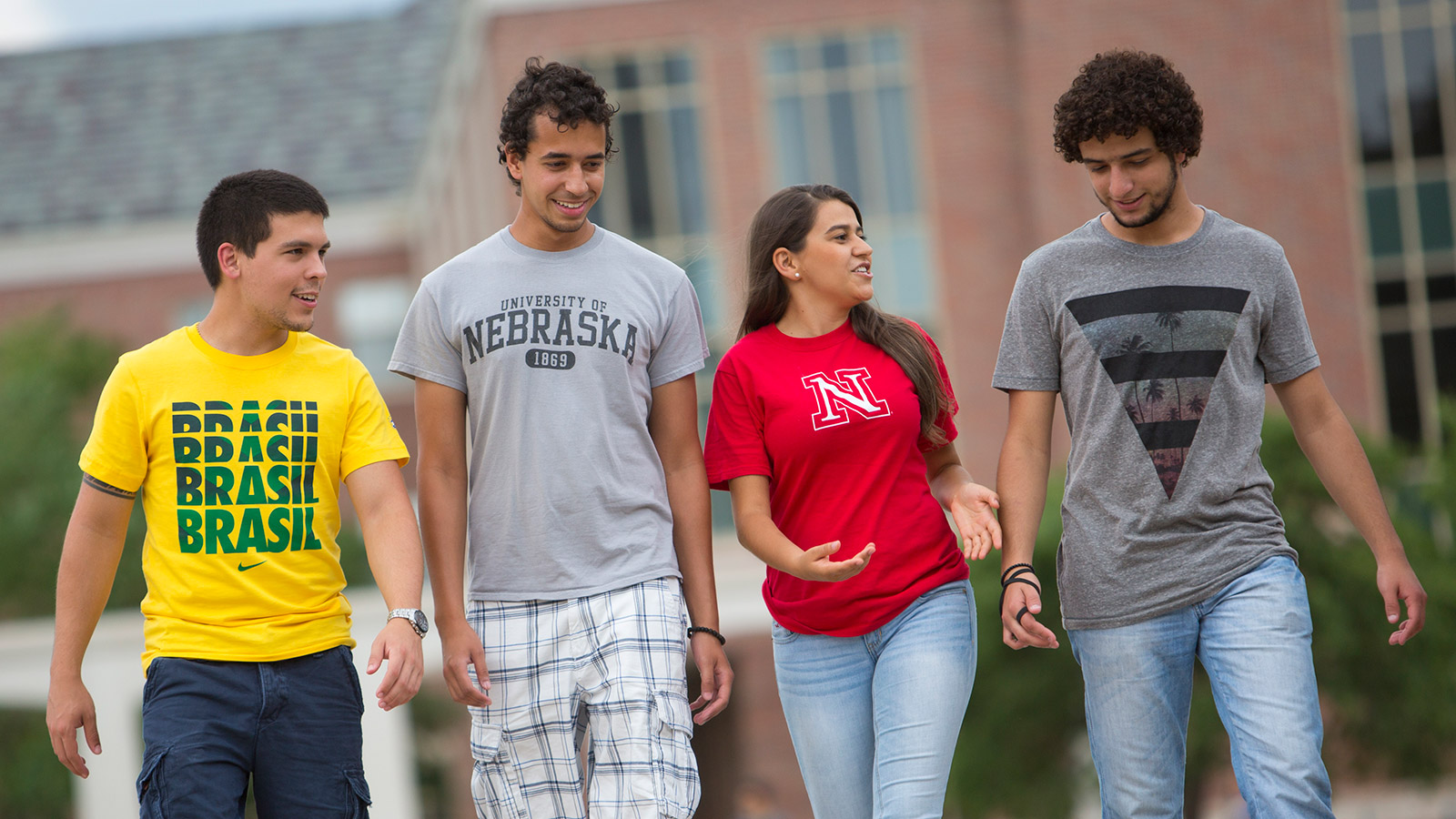 Four Brazilian students talk as they walk across campus.