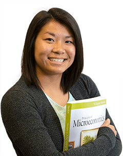 A student holding a microeconomics text book.