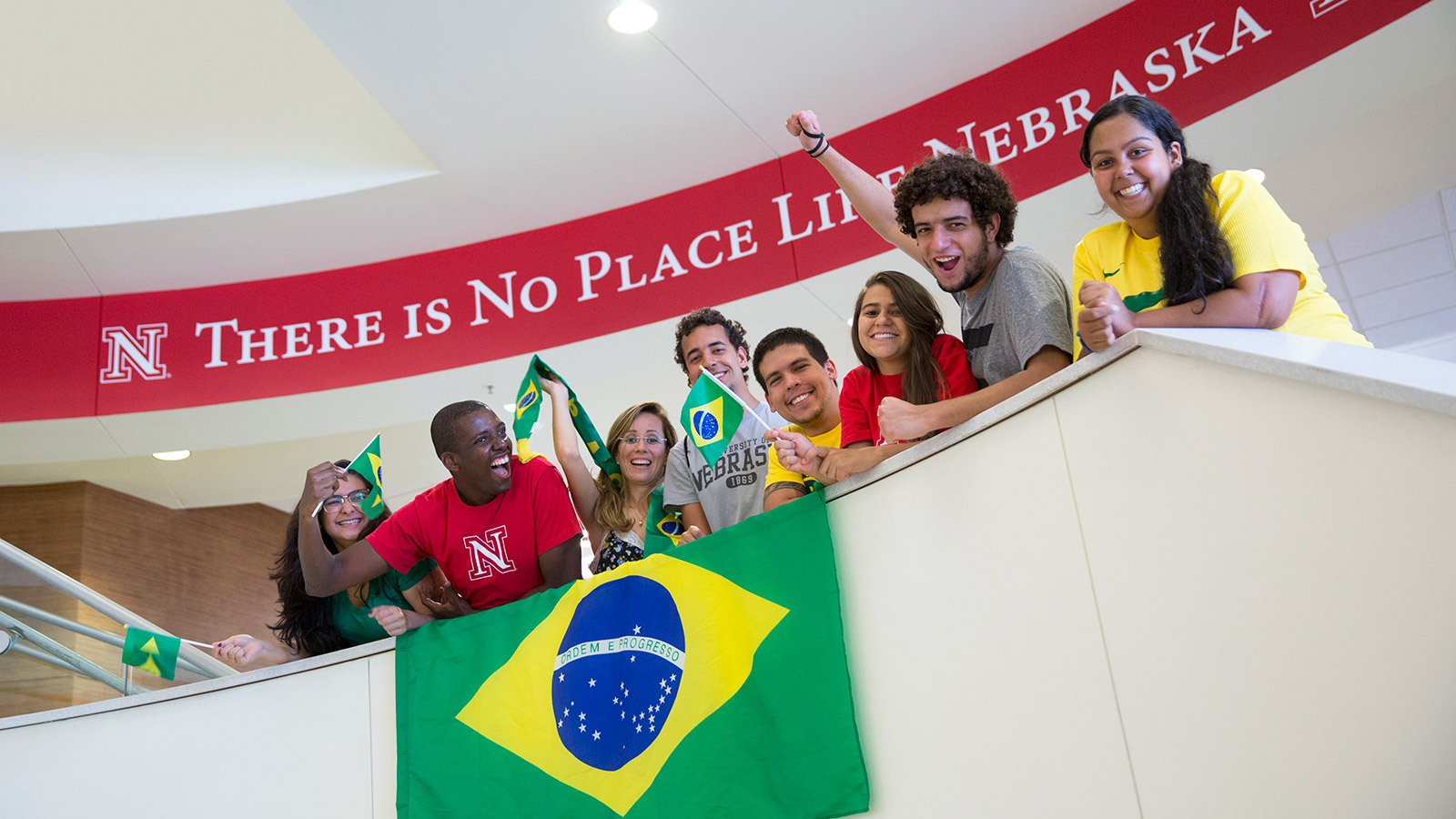 Brazilian students cheer in front of banner.