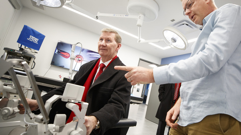 Shane Farritor (right), professor of mechanical and materials engineering, helps Ted Carter control a surgical robot in a Virtual Incision lab at Nebraska Innovation Campus