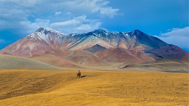 A rider traverses the treeless grassland, or steppe, of Kazakhstan