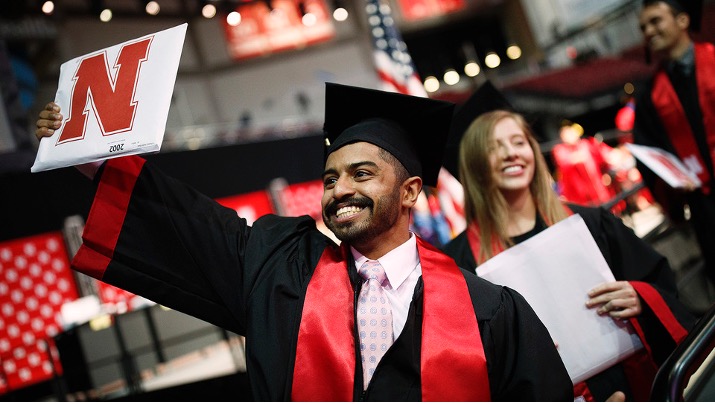 Khaled AlSubaie, an international student from Saudi Arabia, holds up his bachelor's degree during the May 2019 commencement in Pinnacle Bank Arena. Due to COVID-19, recognition for international graduates will be held online.