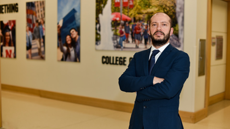 Özgür Araz's research has helped provide modeling tools that public officials and health care workers use to make decisions during pandemics. He poses inside the College of Business.  