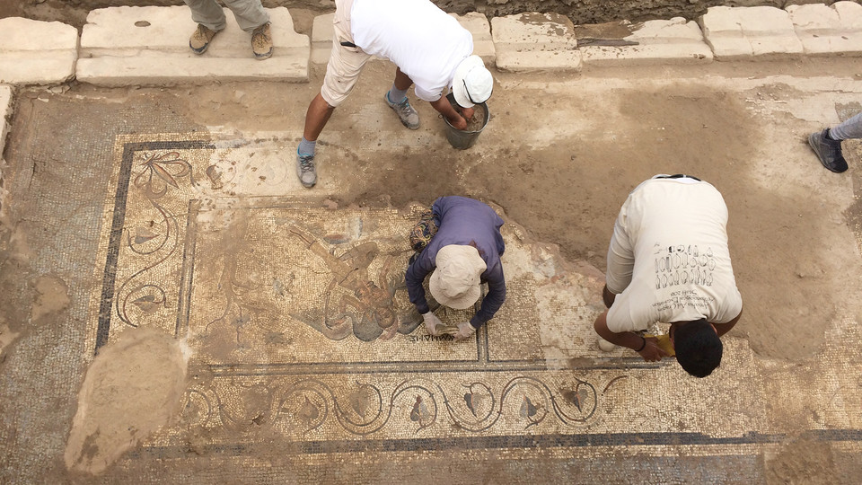 Turkish members of an excavation team led by Nebraska art history professor Michael Hoff sweep dirt away from a new mosaic discovered in August 2018.