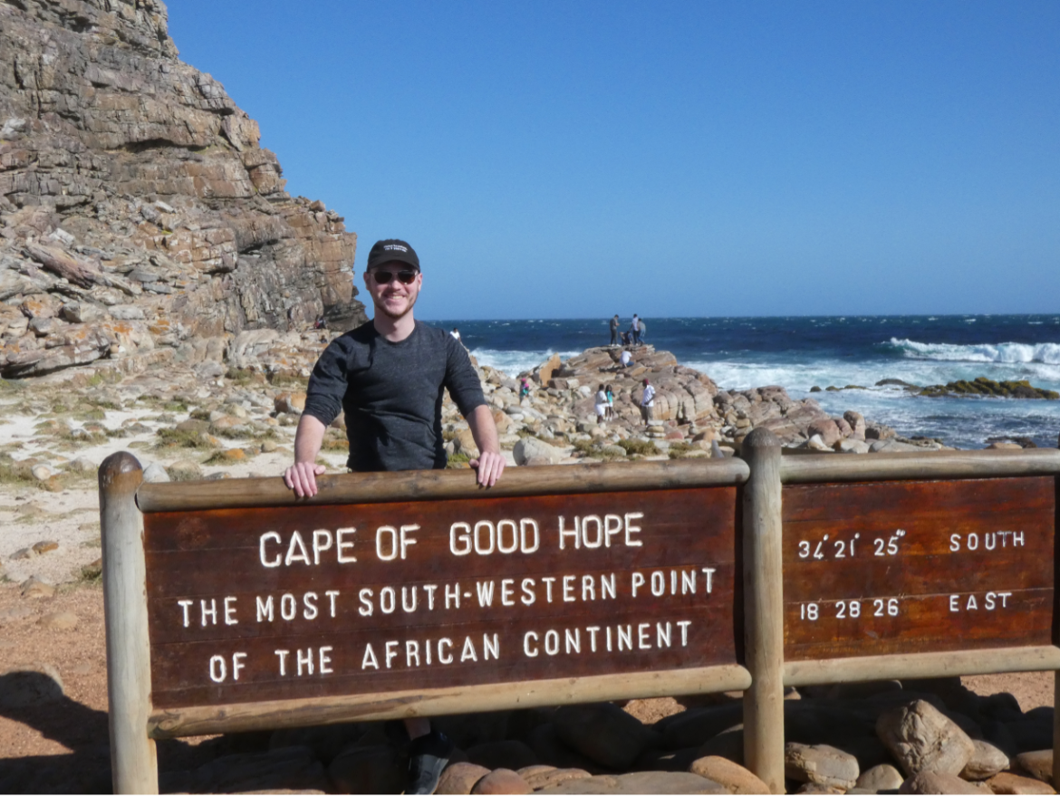 Grant Paisley stands in front of the "Cape of Good Hope" sign. 