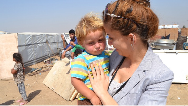 Vianne Sheikh consoles a toddler at a refugee camp in Iraq.