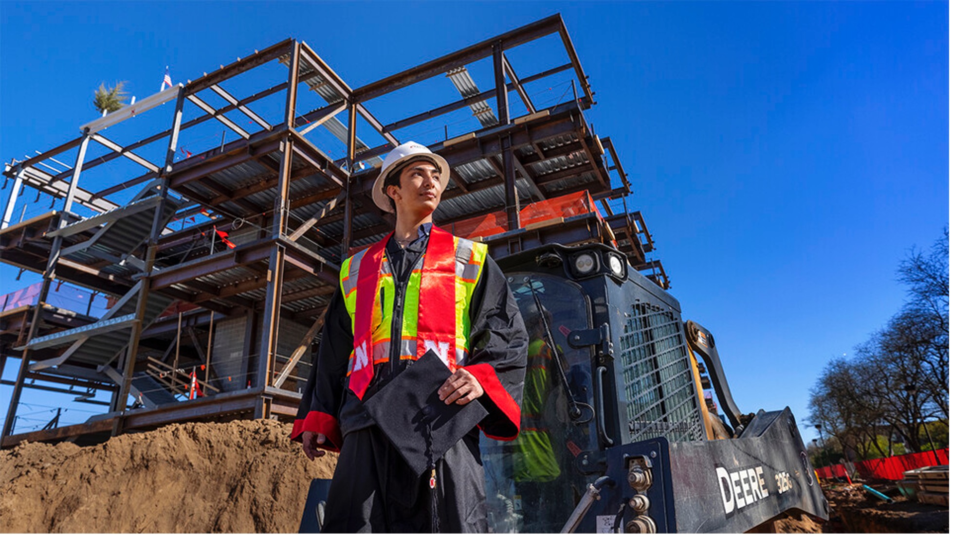 Yajyoo Shrestha, a graduating senior in civil engineering, stands before the construction site of the new College of Education and Human Sciences building on City Campus.