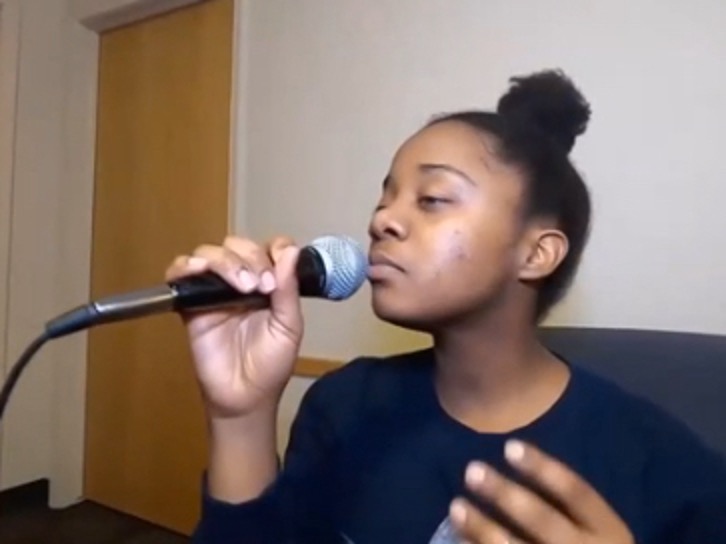 A student is singing for a virtual karaoke. 