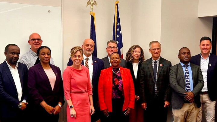 Delegation poses for photo in meeting space. 