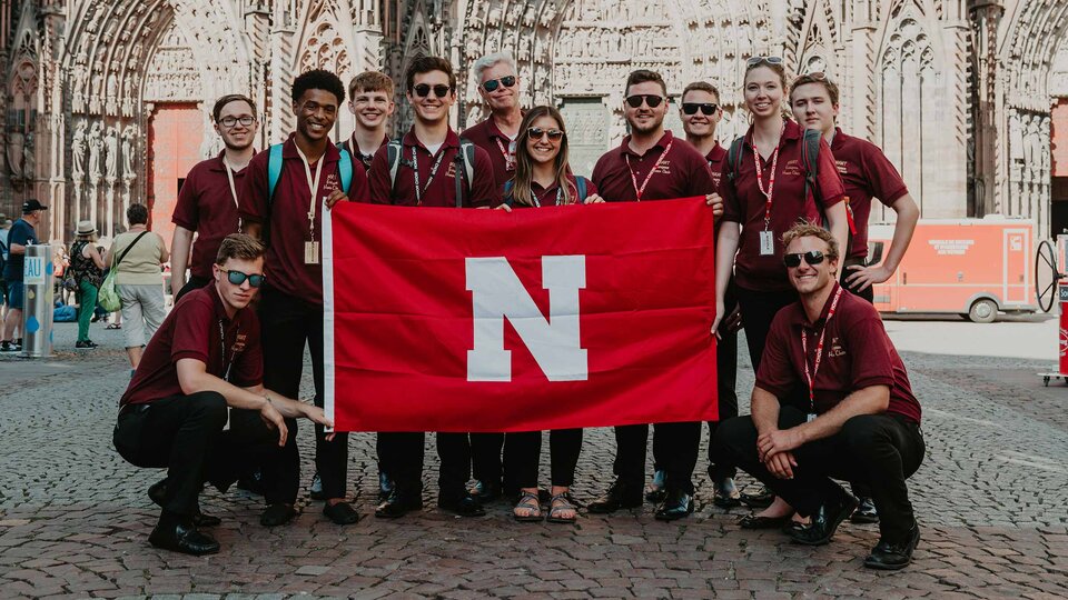 choir students abroad holding an N flag