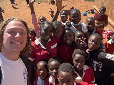 Cole Murphy with group of children abroad