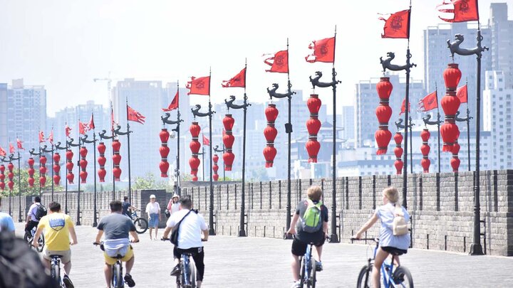 Students riding bikes on street in China.