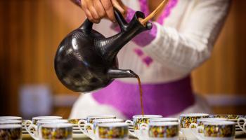 Woman pouring coffee for an Ethiopian coffee ceremony